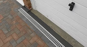 Strip trench drain along a paver driveway