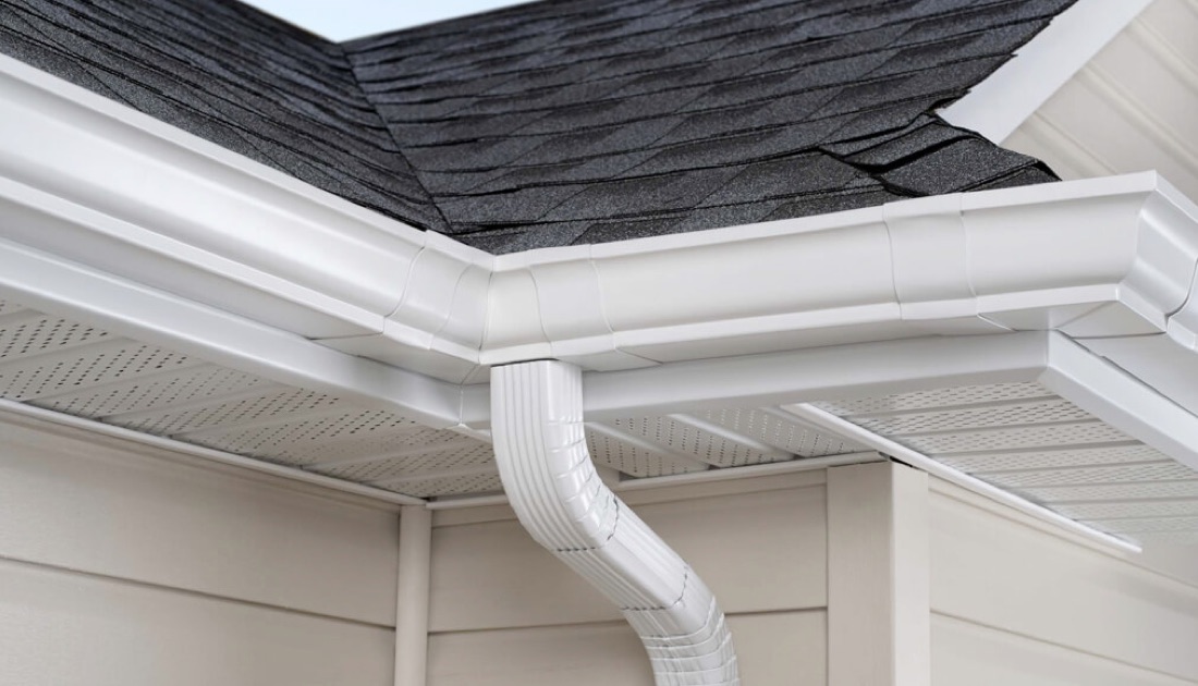 Clean white seamless gutters and downspout on a home